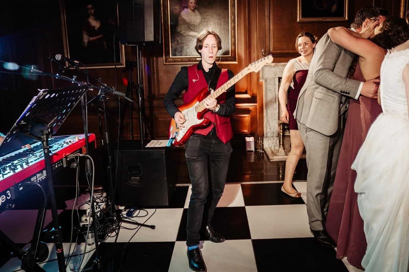 Wedding guitarist performing live during an evening wedding reception celebration
